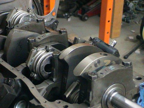 1979 Ford Bronco - Close-up view of an engine's crankshaft and connecting rod assembly, showing bearing caps and bolts.