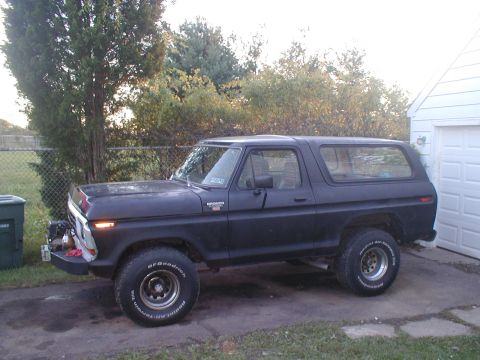 1979 Ford Bronco II - This Ford Bronco is parked on a concrete driveway with a chain-link fence and trees in the background.