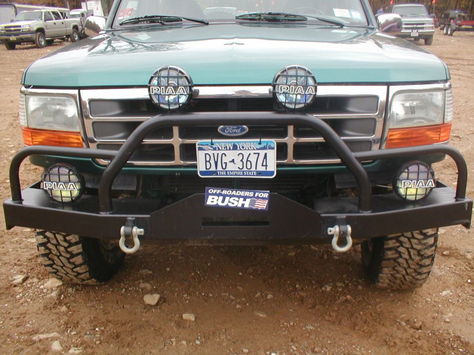 Green Ford truck front view with aftermarket bumper and PIAA lights