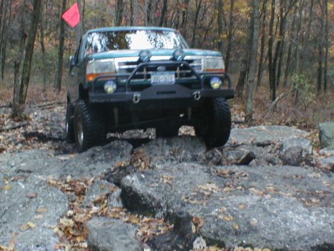 1979 Ford Bronco II - Ford Bronco tackling a challenging off-road course with a red flag on top.