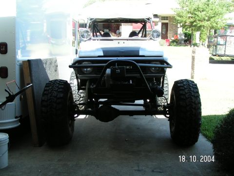 1978 Ford Bronco - This modified Suzuki Samurai features oversized off-road tires and a prominent roll cage, seen from the front.