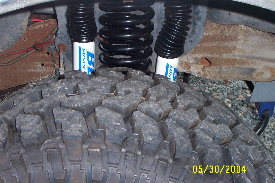 Close-up of lifted suspension and large tire with blue shocks