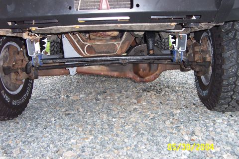 1996 Ford Bronco - The underside of a lifted 4x4 vehicle shows heavy-duty suspension and large off-road tires.