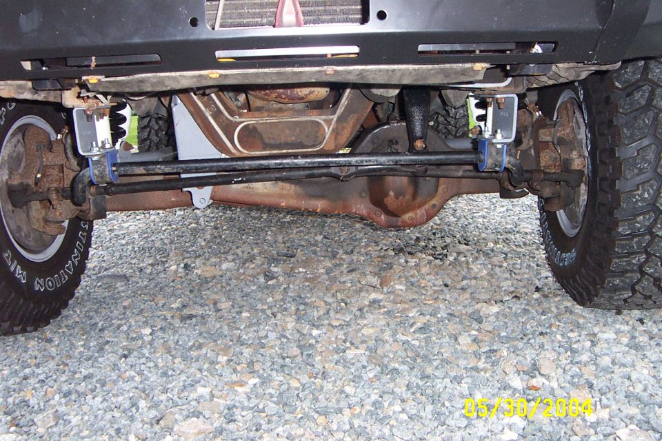 Undercarriage view of a lifted 4x4 with large tires and suspension components visible