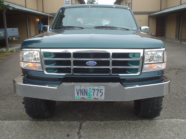 Front view of a green 1993 Ford Bronco with a chrome bumper and license plate VNN 775