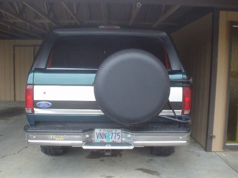 1993 Ford Bronco - This 1993 Ford Bronco is parked in a garage, showing its rear end and spare tire cover.