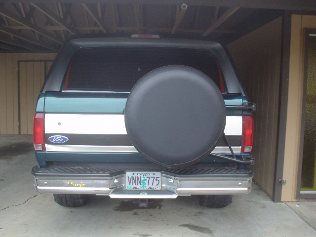 Rear view of a 1993 Ford Bronco with a spare tire on the back. License plate reads VNN 775