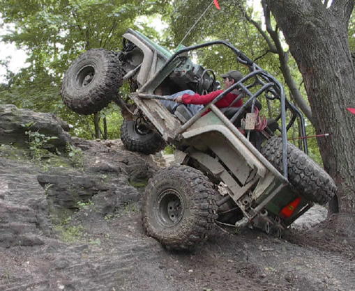 Off-road buggy climbing rocky terrain, driver visible