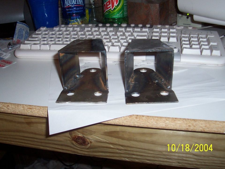 Two welded metal brackets with four mounting holes each