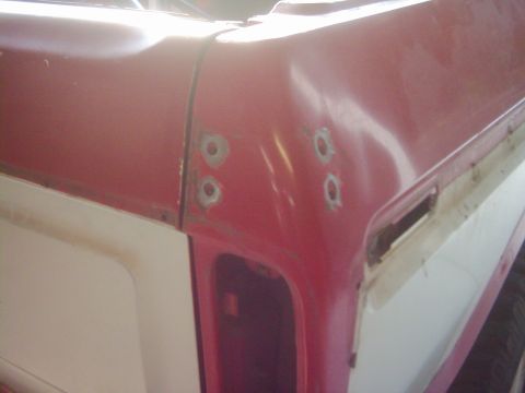 1978 Ford Bronco - Close-up view of the rear corner of a two-tone pickup truck, with visible bodywork imperfections.