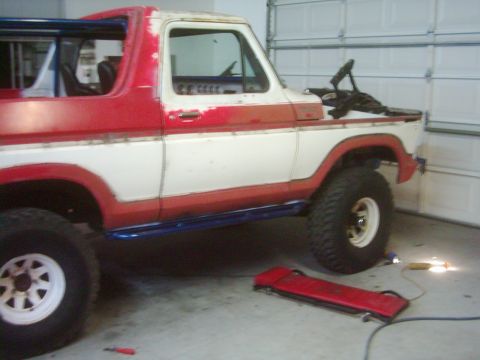 1978 Ford Bronco - This 1978 Ford Bronco is undergoing work in a garage, showing its side profile with custom modifications.