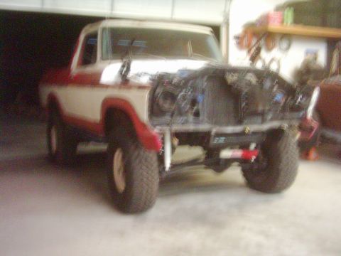 1978 Ford Bronco - A two-tone 1978 Ford Bronco is shown with its hood and grille removed, indicating it is undergoing maintenance or restoration.