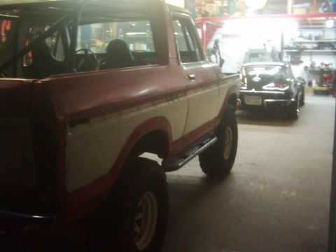1978 Ford Bronco - 1978 Ford Bronco in a garage, showing interior roll cage and exterior two-tone paint.