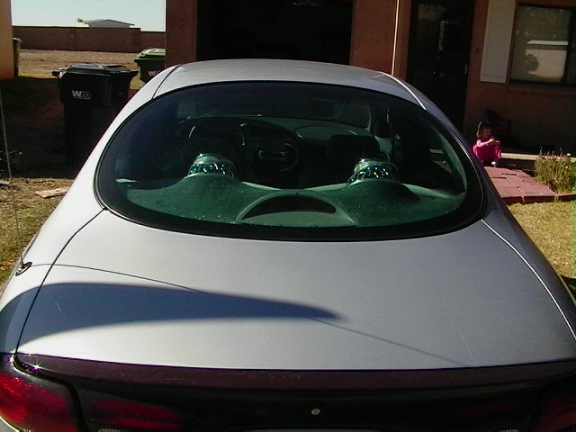 Rear view of a 1999 Ford Taurus showing the trunk lid, taillights, and interior through the rear window