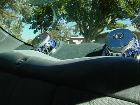 1999 Ford Taurus - Two large subwoofers are mounted on the rear deck of a car, visible from the back seat.