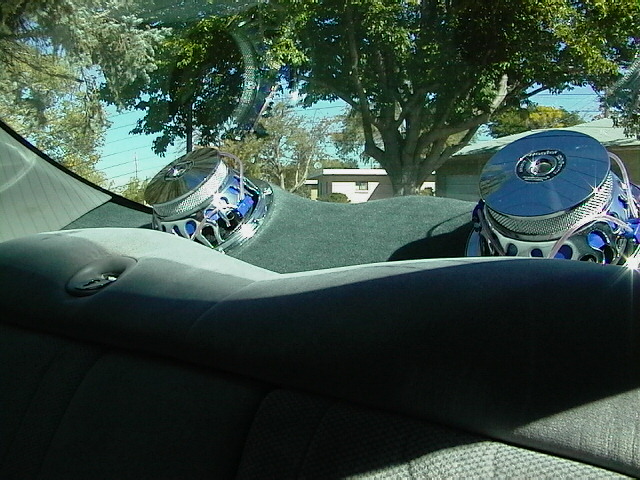 back seat of car with two large subwoofers on the rear deck
