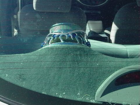 1999 Ford Taurus - Aftermarket car speaker installed on the rear deck of a vehicle.
