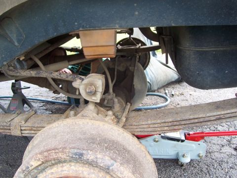 2000 Jeep Cherokee - Underbody view of a vehicle's rear suspension and axle components being worked on.