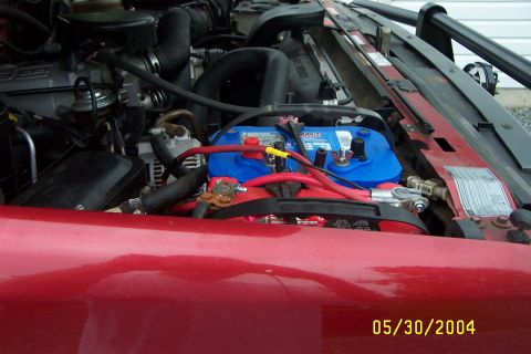 1996 Ford Bronco - Close-up of a vehicle's engine bay, focusing on the battery and wiring.