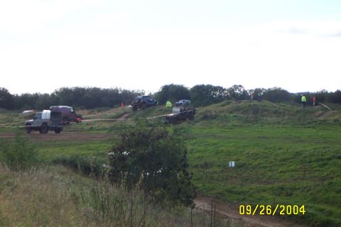 1996 Ford Bronco - Multiple off-road vehicles participate in an event on a grassy course with spectators present.