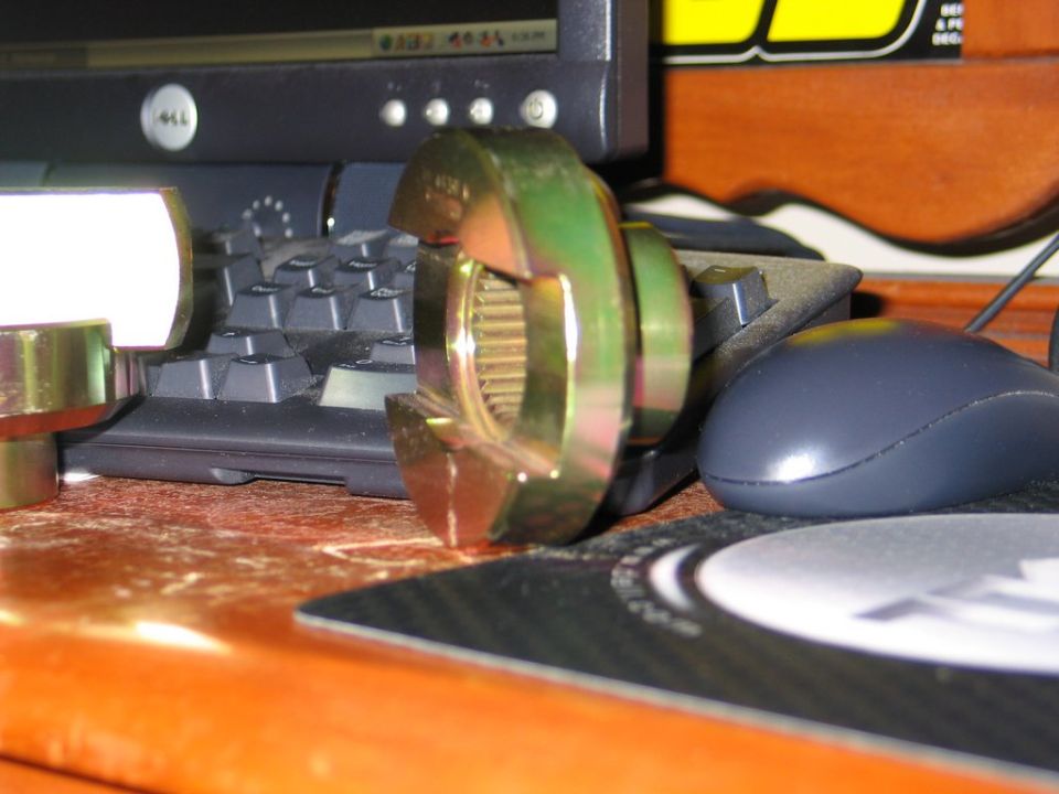 Gold-plated splined differential spool on a desk near a keyboard and mouse