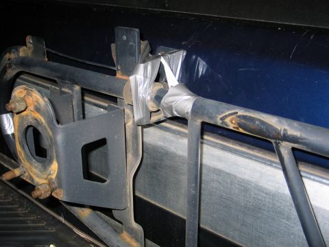 1995 Ford Bronco - Metal tubing and brackets, possibly part of a roll cage or roof rack, secured with duct tape.
