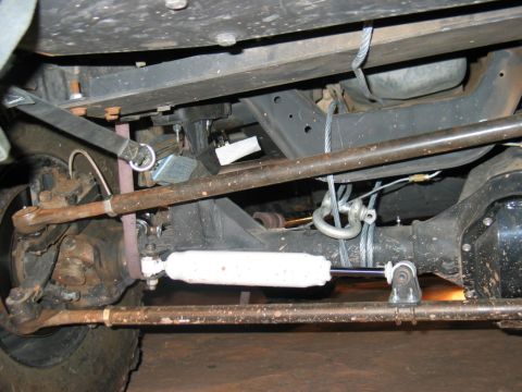 1993 Ford Bronco - Close-up view of the undercarriage of a vehicle, focusing on the suspension and steering mechanisms.