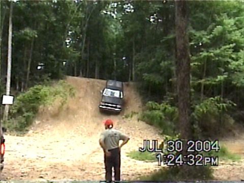 1988 Ford Bronco - A black 1988 Ford Bronco navigates an off-road trail on a sunny day.