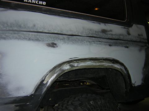 1984 Ford Bronco - This 1980s Ford Bronco is undergoing bodywork, with primer and filler visible on the rear quarter panel.