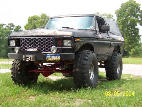 1978 Ford Bronco - Black full-size Ford Bronco with a soft top, photographed from the front three-quarter angle on grass beside a paved lot, dated 08/05/2004.…