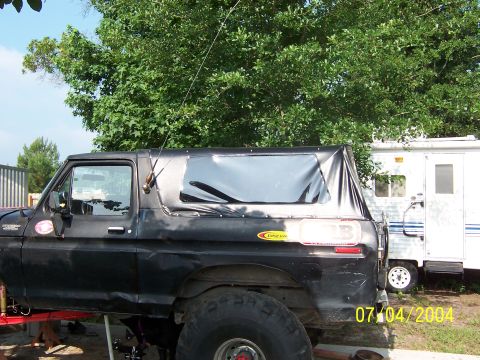 1978 Ford Bronco - Side view of a black 1978 Ford Bronco a soft top and parked outdoors.