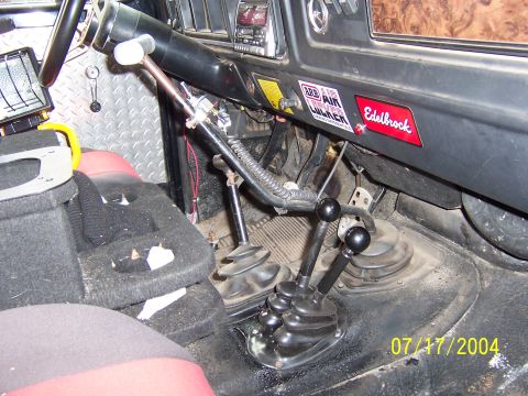 1978 Ford Bronco - Interior floor shot of a 4x4 showing a tall bent shifter with a white knob alongside two black-ball transfer case and transmission levers r…