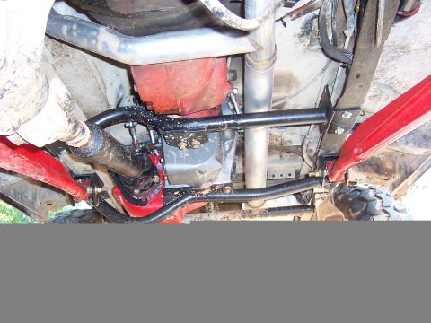 1978 Ford Bronco - Underside view reveals red suspension components and a red transmission housing, with exhaust pipes and drivetrain visible.