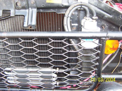 1978 Ford Bronco - Close-up of a custom expanded-metal mesh grille built into a black tube front bumper/brush guard, dated 10/03/2004. Behind the mesh sit a r…