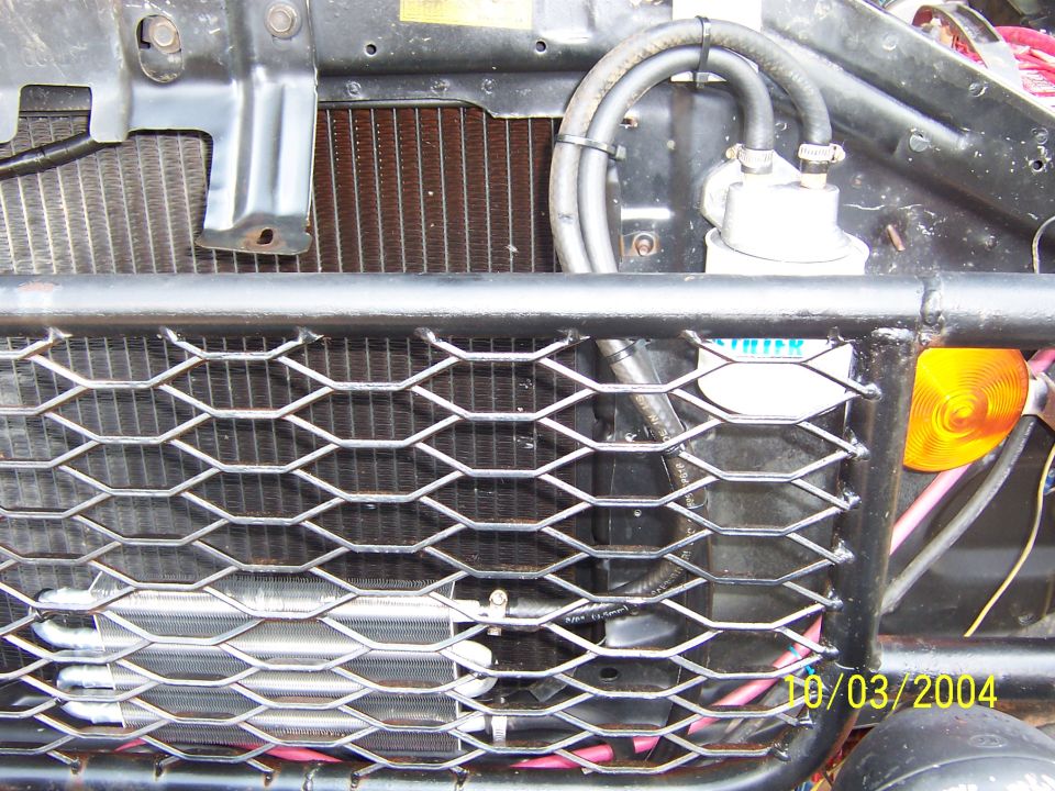 Expanded metal grille in tube bumper showing radiator, auxiliary cooler and amber turn signal