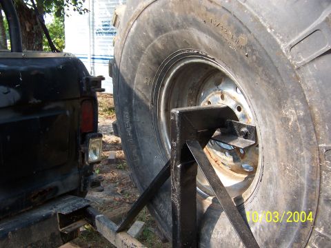 1978 Ford Bronco - A large spare tire is mounted on a carrier, attached to the rear of a black vehicle.