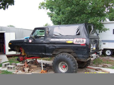 1978 Ford Bronco - Black lifted full-size Ford Bronco with a black soft top, ARB and HighAngleDriveline.com decals on the body side, sitting on jack stands mi…