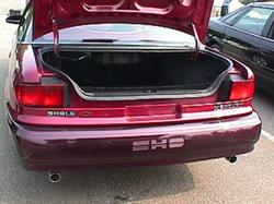 1995 Ford Taurus - Rear view of a red sedan, possibly a 1995 Ford Taurus SHO, with its trunk open.