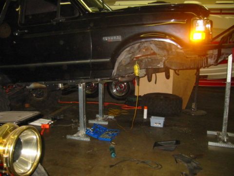 1992 Ford Bronco - This 1992 Ford Bronco is shown on lifts with its front fender removed, indicating ongoing maintenance or modification.