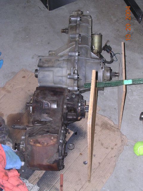 1994 Ford Bronco - Transmission and transfer case assembly, likely for a 4x4 vehicle, on a workshop floor.