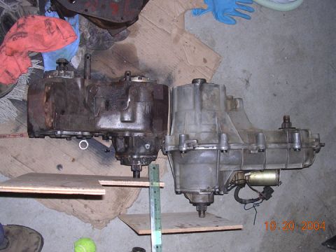 1994 Ford Bronco - Comparison of two vehicle transfer cases, one appears older and more worn than the other.