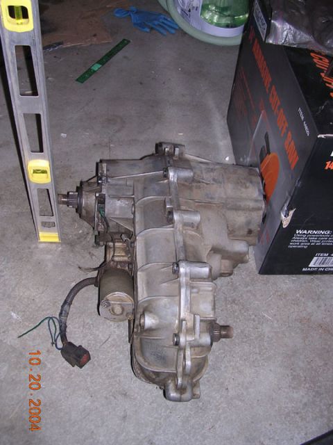 1994 Ford Bronco - A transfer case is shown with a date stamp of October 20, 2004, next to a cut-off saw box.