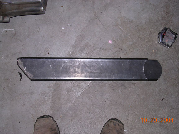 Metal bracket with angled and rounded ends on concrete floor. Date stamp reads 10.20.2004