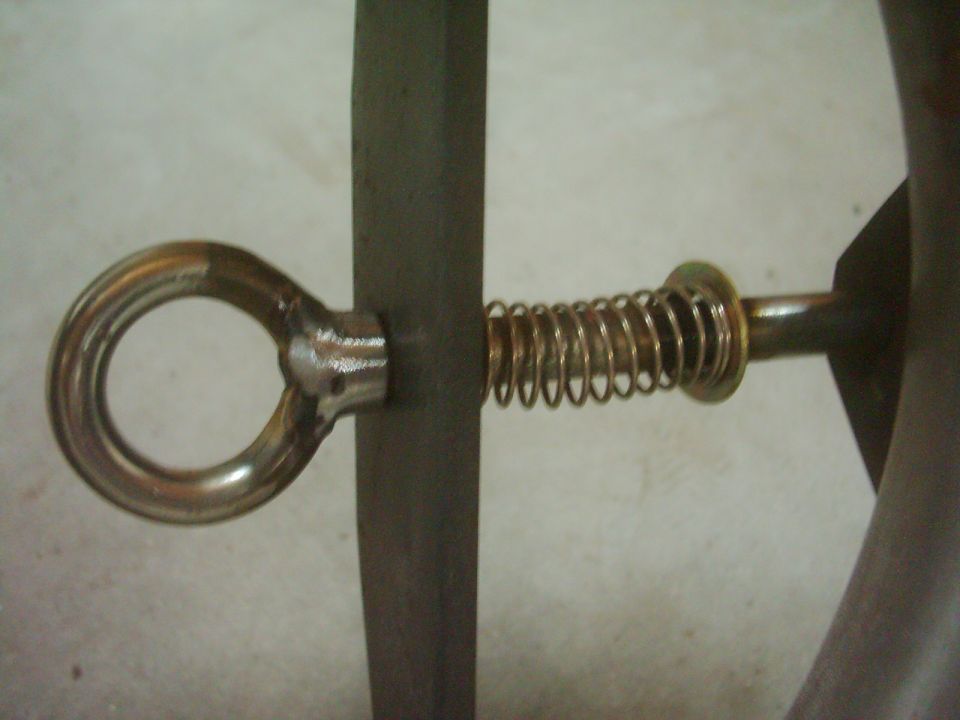 Close-up of a door latch mechanism with a spring and eyelet