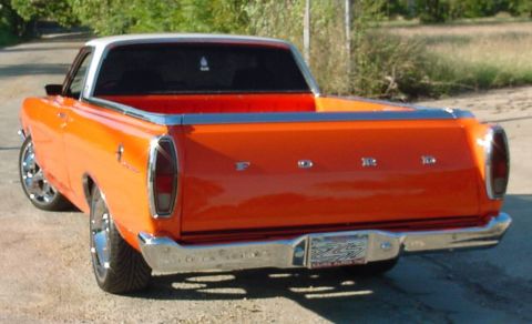 1969 Ford Ranchero - Rear view of an orange 1969 Ford Ranchero pickup truck with a white roof and chrome accents.