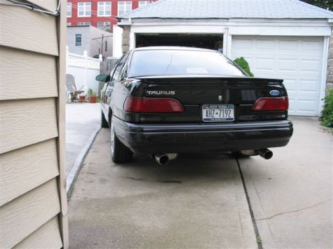 1995 Ford Taurus - Rear view of a black 1995 Ford Taurus sedan parked in a driveway.