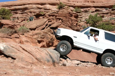 1993 Ford Bronco - White 1993 Ford Bronco navigating a challenging rocky trail.