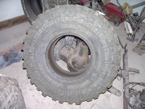 1978 Ford Bronco - Close-up of a Super Swamper tire and visible suspension parts, not a complete vehicle.