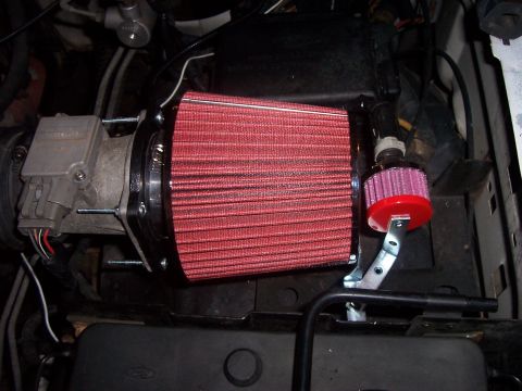 1994 Ford Bronco - Aftermarket red cone air filter installed on the engine's intake system.