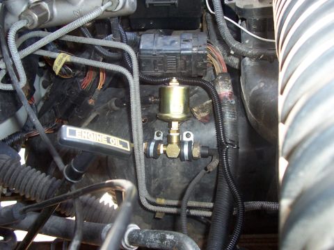 1994 Ford Bronco - Close-up view of engine components including an oil dipstick and a pressure gauge.